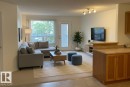 Bright living area featuring a large window, light-toned walls, and track lighting - #6201 7331 South Terwillegar Dr Nw, Edmonton, AB  - Indoor Photo Showing Living Room 