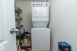 Dedicated laundry area featuring a stacked washer and dryer - 