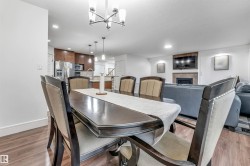 Dining area featuring wood-finish flooring, recessed lighting, and a modern chandelier - 