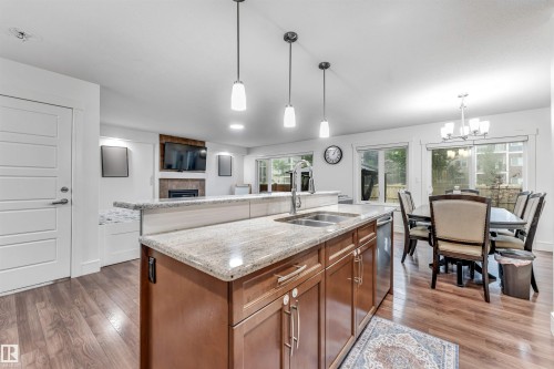 Kitchen island with a double basin sink, light-colored countertop, and integrated dishwasher - 6727 20 Ave Sw, Edmonton, AB - Indoor Photo Showing Kitchen With Double Sink