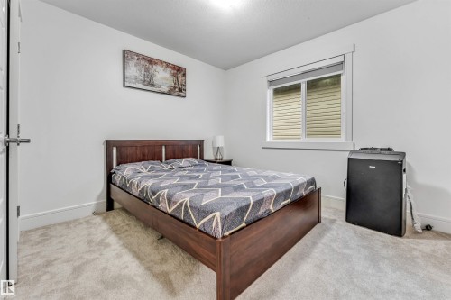 Carpeted room featuring a double-paned window with blinds, white trim, and light-colored walls - 6727 20 Ave Sw, Edmonton, AB - Indoor Photo Showing Bedroom