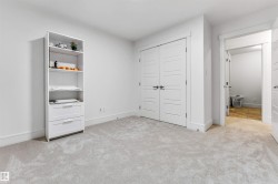 Wall-to-wall light gray carpeting, white baseboards, and bright white walls define this interior space - 