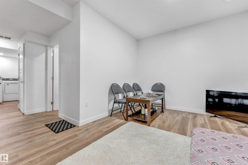 Bright living space featuring wood-finish flooring, white baseboards, and a neutral color palette - 6727 20 Ave Sw, Edmonton, AB - Indoor