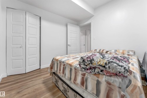 Bright bedroom featuring wood-finish flooring and white walls - 6727 20 Ave Sw, Edmonton, AB - Indoor Photo Showing Bedroom