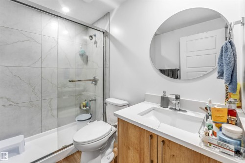 Bathroom featuring a glass-enclosed shower with large format marble-look tile surround and a chrome shower head - 6727 20 Ave Sw, Edmonton, AB - Indoor Photo Showing Bathroom