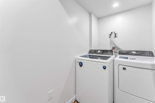 Dedicated laundry area featuring a white top-load washing machine and front-load dryer - 6727 20 Ave Sw, Edmonton, AB - Indoor Photo Showing Laundry Room