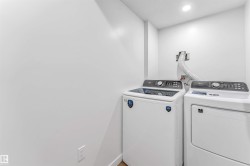 Dedicated laundry area featuring a white top-load washing machine and front-load dryer - 
