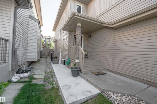 Covered front entrance featuring a stone-clad support column and wood-finish steps - 6727 20 Ave Sw, Edmonton, AB - Outdoor