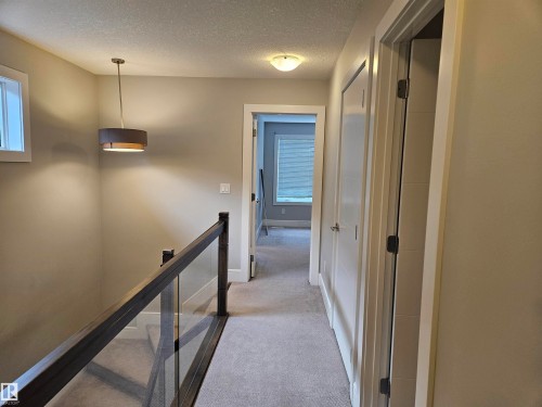 Upper-level hallway featuring a contemporary drum pendant light, recessed window, and carpeted flooring - 9311 66 Avenue Nw, Edmonton, AB - Indoor Photo Showing Other Room