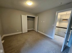 Neutral-toned room featuring wall-to-wall carpeting, white baseboards, and a built-in closet with bi-fold doors - 