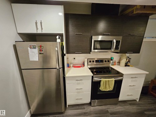 Compact kitchen featuring a stainless steel refrigerator and range - 9311 66 Avenue Nw, Edmonton, AB - Indoor Photo Showing Kitchen