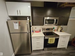 Compact kitchen featuring a stainless steel refrigerator and range - 