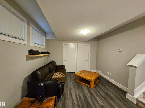 Finished living space featuring wood-finish flooring, light grey walls, and white trim - 9311 66 Avenue Nw, Edmonton, AB - Indoor Photo Showing Other Room