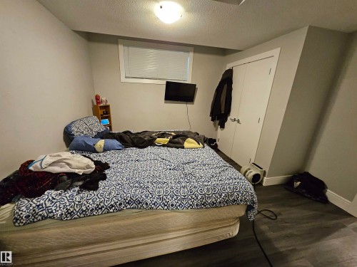 Interior room featuring wood-finish flooring, light gray walls, and white trim - 9311 66 Avenue Nw, Edmonton, AB - Indoor Photo Showing Bedroom