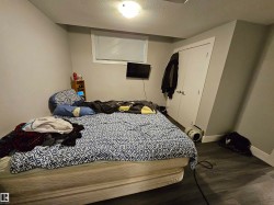 Interior room featuring wood-finish flooring, light gray walls, and white trim - 