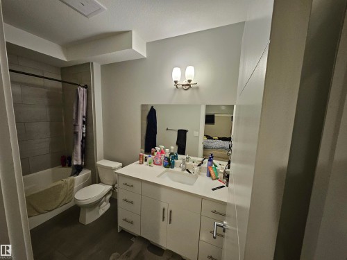 Bathroom featuring a white vanity with a single sink, an integrated countertop, and brushed nickel hardware - 9311 66 Avenue Nw, Edmonton, AB - Indoor Photo Showing Bathroom