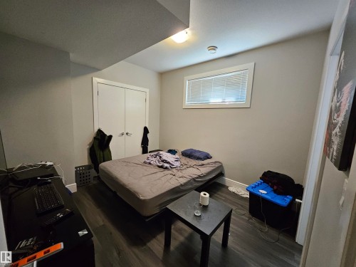 Room featuring wood-finish flooring, neutral wall paint, and a window with blinds - 9311 66 Avenue Nw, Edmonton, AB - Indoor
