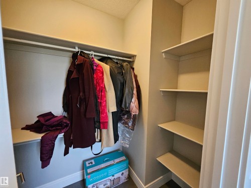 Entryway closet featuring a built-in hanging rod, upper shelf, and three side shelves - 9311 66 Avenue Nw, Edmonton, AB - Indoor With Storage