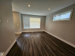 Spacious room featuring wood-finish flooring, recessed lighting, and ample natural light from two windows - 