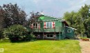 Green-sided home with a prominent second-story balcony featuring wood railings - 54046 Rge Road 213, Rural Strathcona County, AB  - Outdoor 