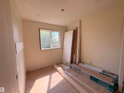 Recessed lighting fixtures illuminate a room featuring a window with a green outdoor scenery - 