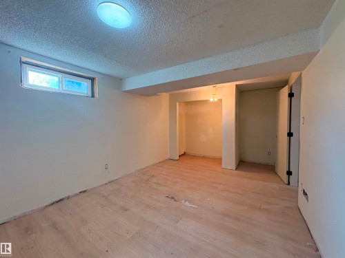 Spacious room with light wood-finish flooring, a recessed window, and neutral wall tones - 18007 73 Avenue Nw, Edmonton, AB - Indoor