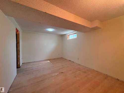 Expansive room with neutral painted walls and a window providing natural light - 18007 73 Avenue Nw, Edmonton, AB - Indoor