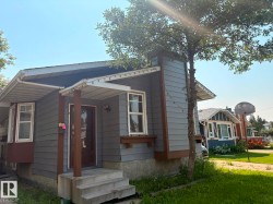 Siding exterior with a covered porch and concrete steps - 