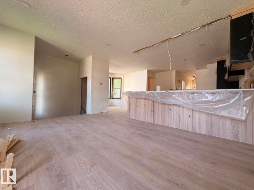 Newly installed wood-finish flooring extends throughout the main living space - 18007 73 Avenue Nw, Edmonton, AB - Indoor