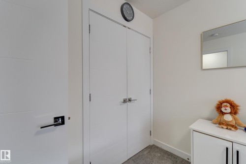 Modern interior featuring a double-door closet with contemporary hardware - #8 1703 16 Av Nw Nw, Edmonton, AB - Indoor Photo Showing Other Room