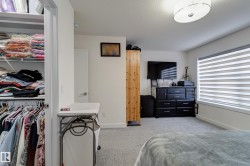 Bedroom featuring light gray carpeting, neutral wall paint, and a window with horizontal blinds - 