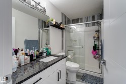 Modern bathroom featuring a single vanity with a granite countertop, white cabinetry, and a rectangular undermount sink - 