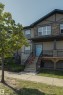 Multifaceted exterior featuring stone accents, horizontal siding, and a prominent front entrance with a bright blue door - #8 1703 16 Av Nw Nw, Edmonton, AB  - Outdoor 