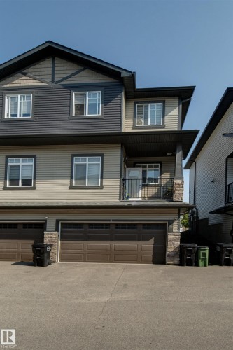 Multi-level residence featuring a multi-tone facade with dark siding and light horizontal siding - #8 1703 16 Av Nw Nw, Edmonton, AB - Outdoor