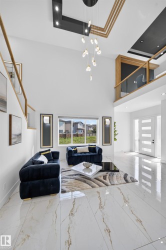 Vaulted ceiling featuring a multi-tier chandelier - 112 Ross Close, Leduc, AB - Indoor Photo Showing Other Room