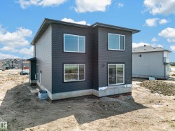 Modern two-story residence featuring dark grey horizontal siding and white-framed windows - 