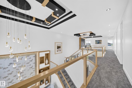 Dramatic two-story foyer with a multi-tiered ceiling feature, contemporary chandelier, and recessed lighting - 112 Ross Close, Leduc, AB - Indoor Photo Showing Other Room