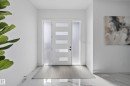 Contemporary entry door with frosted glass panels and sidelights, complemented by polished marble-look flooring - 112 Ross Close, Leduc, AB  - Indoor Photo Showing Other Room 