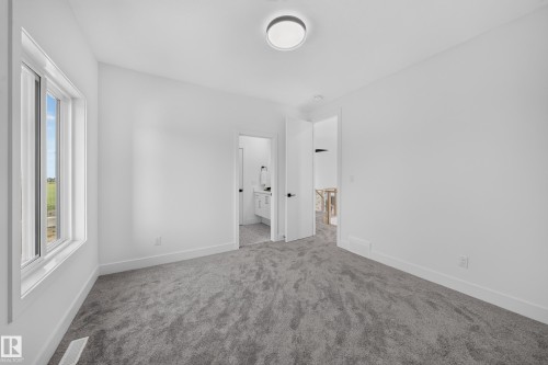Carpeted room with a ceiling-mounted light fixture and a single window - 112 Ross Close, Leduc, AB - Indoor Photo Showing Other Room
