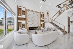 Bright interior space featuring a double-height ceiling, large windows, and polished tile flooring - 