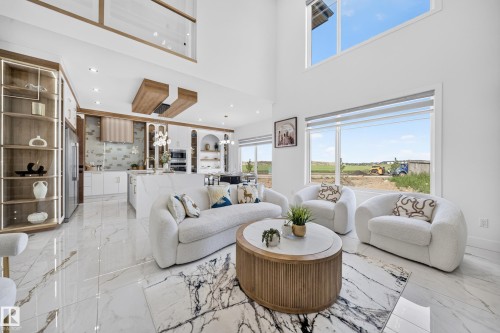 Spacious living area featuring high ceilings, large windows, and polished tile flooring - 112 Ross Close, Leduc, AB - Indoor Photo Showing Living Room