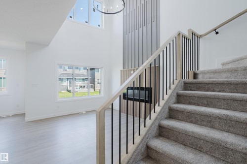 Open-concept living space with a tall white wall and high windows - 8728 182 Avenue Nw, Edmonton, AB - Indoor Photo Showing Other Room