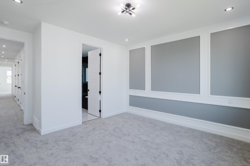 Room featuring a decorative accent wall with panel molding and a light gray finish - 8728 182 Avenue Nw, Edmonton, AB - Indoor Photo Showing Other Room