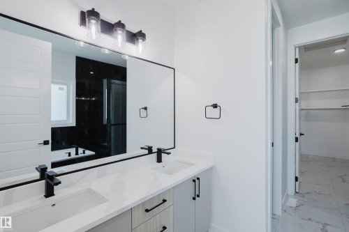 Double vanity with white countertops, undermount sinks, and matte black fixtures - 8728 182 Avenue Nw, Edmonton, AB - Indoor Photo Showing Bathroom
