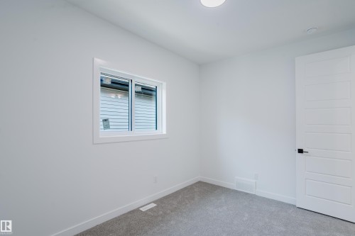 Neutral interior space featuring light gray carpeting, crisp white walls, and a recessed ceiling light - 8728 182 Avenue Nw, Edmonton, AB - Indoor Photo Showing Other Room