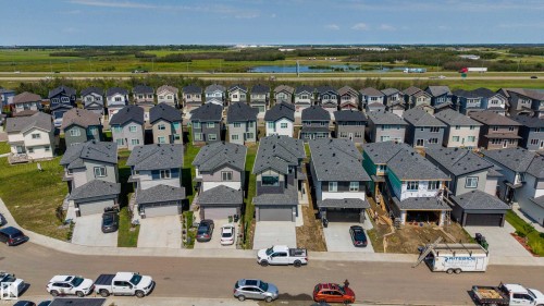 Newly constructed residential properties featuring attached garages, dark shingle roofs, and light-colored siding - 8728 182 Avenue Nw, Edmonton, AB - Outdoor With View