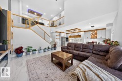 Open-concept living area with high ceilings and wood-finish accents - 
