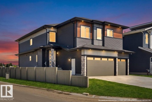 Contemporary exterior featuring dark horizontal siding, stone accents, and wood-panel detailing - 6001 19 Street, Nisku, AB - Outdoor