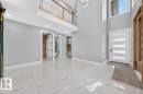 Two-story entryway featuring high ceilings, large format tile flooring, and a contemporary light fixture - 6001 19 Street, Nisku, AB  - Indoor Photo Showing Other Room 