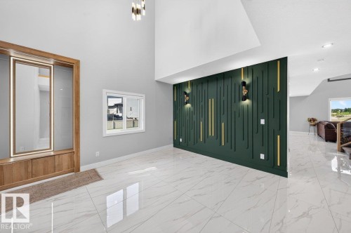 Soaring ceilings with an elegant decorative accent wall, featuring integrated sconce lighting and vertical gold-tone detailing - 6001 19 Street, Nisku, AB -  Photo Showing Other Room